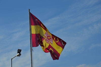 Low angle view of flag against blue sky