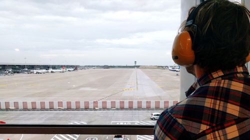 View of airplane at airport runway against sky