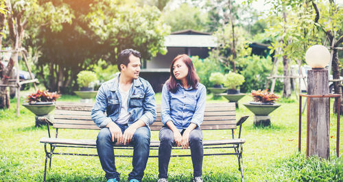 Young couple sitting on bench in park