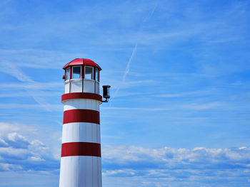 Lighthouse by sea against sky