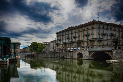 Bridge over river against cloudy sky