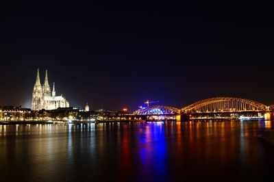 Illuminated city with rhine river against clear sky