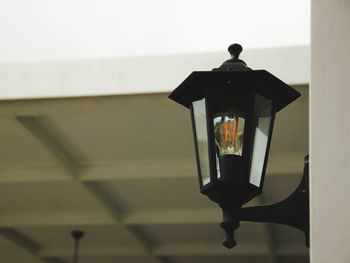 Close-up of illuminated lamp on wall in building