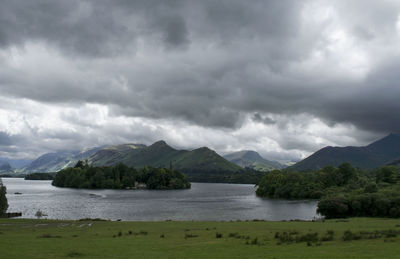 Scenic view of river by mountains against sky