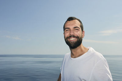 Portrait of smiling man in sea against sky