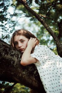 Portrait of girl against tree trunk