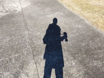 Shadow of man on road