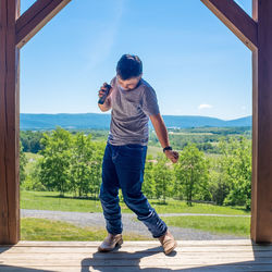 Full length of boy standing on mountain against sky