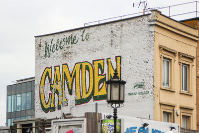 Low angle view of text on building against sky