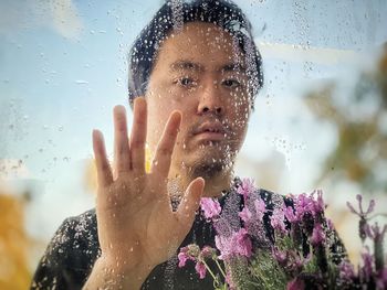 Portrait of man on wet glass