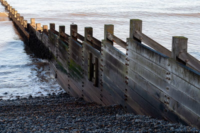 High angle view of wooden groyne on beach