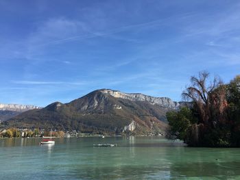 Scenic view of lake and mountains against blue sky