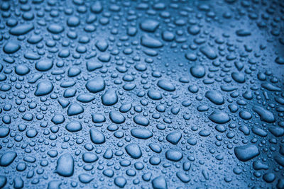 Full frame shot of raindrops on blue background