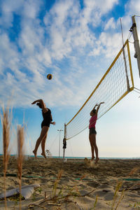 Low angle view of woman playing beach volleyball