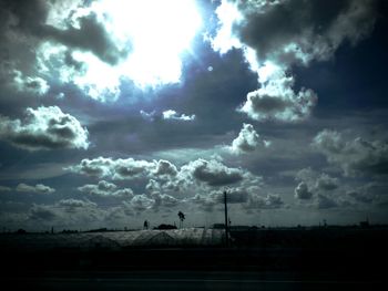 Low angle view of cloudy sky over silhouette landscape