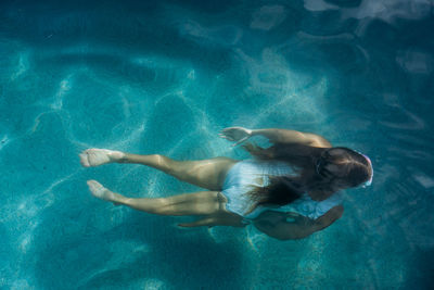 Young girl swimming in sea or pool under water