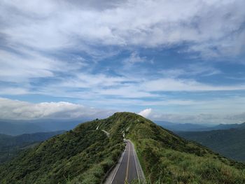 Panoramic view of road leading towards mountains against sky