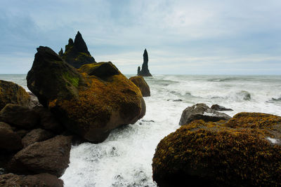 Rocks on beach against sky