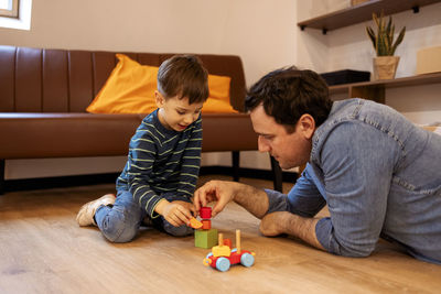 Boy playing with toy blocks at home