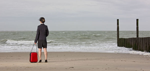 Business woman standing on empty beach