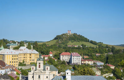 Buildings in town against clear blue sky