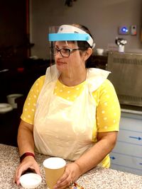 Portrait of woman serving in a cafe  wearing face shield