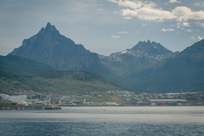 Scenic view of sea by mountains against sky