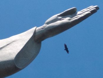 Low angle view of hand statue against clear blue sky