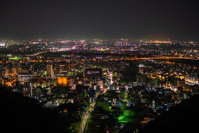 High angle view of illuminated city against sky at night