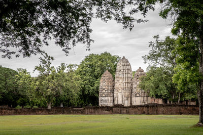 Built structure by trees against sky