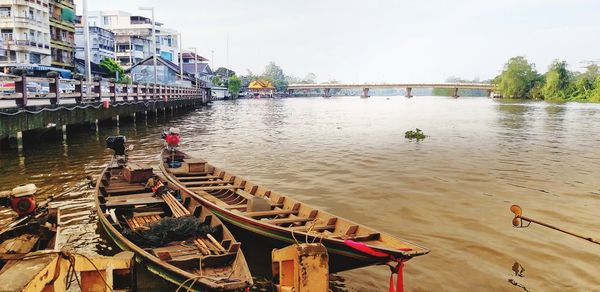 Scenic view of river by buildings against sky