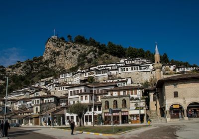 Buildings in city against clear blue sky