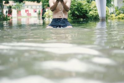 Midsection of man swimming in pool