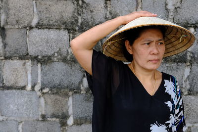 Mature woman wearing casuals while standing against wall