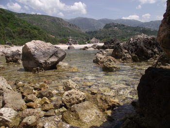 Scenic view of river and mountains against sky