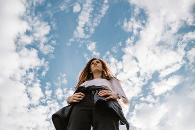 Low angle view of woman standing against sky