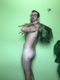 Portrait of young man standing against wall