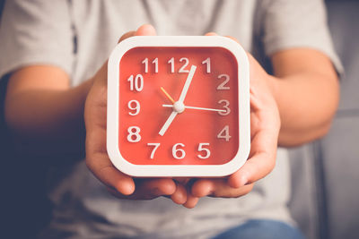 Close-up of hand holding clock