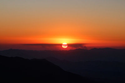 Scenic view of silhouette mountains against romantic sky at sunset