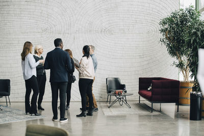 Business people discussing while standing in meeting at office