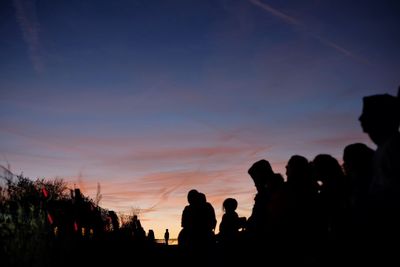 Silhouette people against sky during sunset