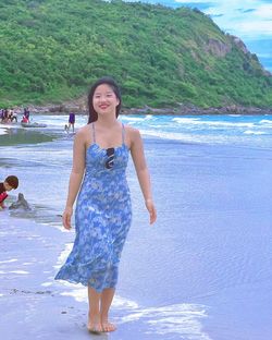 Portrait of young woman standing at beach