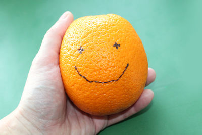 Cropped hand holding orange