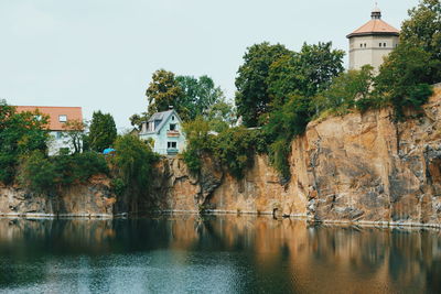 Houses by river and buildings against sky