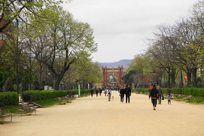 People walking on footpath amidst buildings in city