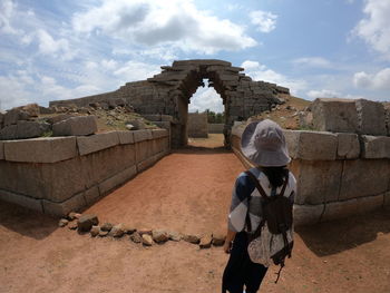 Rear view of woman standing at old ruin