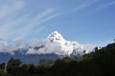 Low angle view of snowcapped mountain against sky