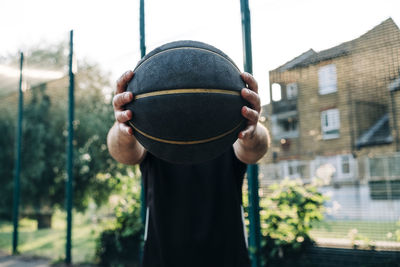 Athlete holding black basketball at court