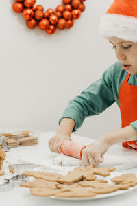 Portrait of girl playing with gingerbread cookies on table