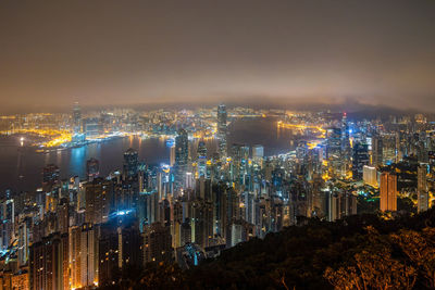 High angle view of illuminated cityscape against sky at night